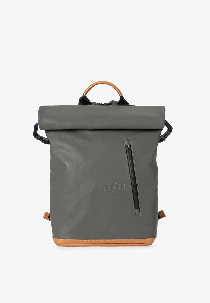 Gray roll-top backpack with a brown leather base, featuring a front zip pocket, padded straps, and a wooden handle. Smooth texture.