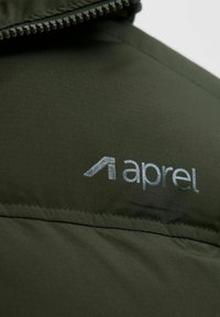 Dunkelgrüne gepolsterte Jacke mit einem Reißverschluss. Sie hat eine glatte Textur und der Markenname "aprel" ist in hellgrau auf dem Stoff gedruckt.