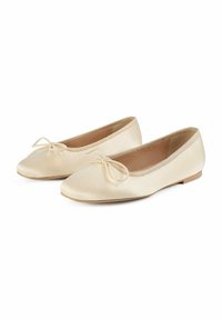Ballerines en satin beige clair avec un bout rond, un petit nœud à l'avant et une semelle plate et fine. Texture lisse avec un design minimal.