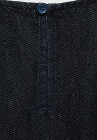 Tmavě modrá džínová látka s knoflíkovým uzávěrem, předním zapínáním a viditelnými švy; hladká textura s klasickým designem.