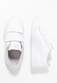 Sneaker bianche con parte superiore in sintetico liscio, cinturini in Velcro, accenti grigi, collare imbottito e soletta testurizzata. Design classico.