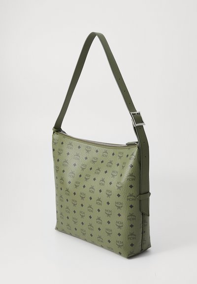 Green leather shoulder bag with a smooth texture, featuring a pattern of black logos and diamond shapes. Silver hardware accentuates the design.