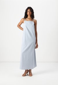 Ανοιχτό μπλε, αμάνικο μαξι φόρεμα με απλό ορθογώνιο μπούστο, μαλακή υφή υφάσματος και ίσια τελειώματα. Φοριέται με μπεζ λουράτα ψηλοτάκουνα.