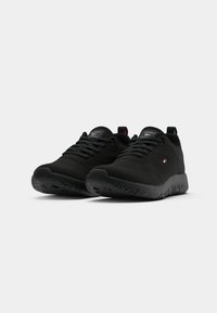 Black athletic shoes with textured synthetic upper, round toe, lace-up design, and durable rubber sole featuring a patterned tread.
