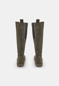 Stivali al ginocchio in suede verde con finitura testurizzata, caratterizzati da una zip nera sul lato esterno e un tacco rinforzato.