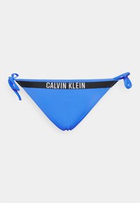 Parte de baixo de bikini azul feita de tecido suave. Apresenta uma faixa preta com o logótipo "CALVIN KLEIN" e laços em cada lado para ajuste.