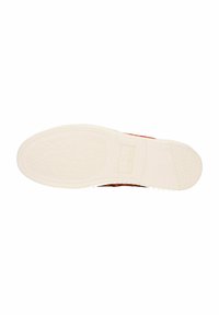 Gumowa podeszwa sportowego buta z teksturowaną białą powierzchnią; posiada wytłoczone logo oraz gładkie krawędzie. Lekko wygięty czubek dla ergonomicznego designu.