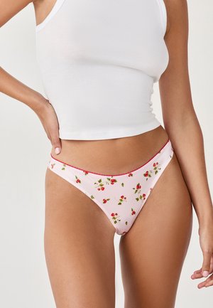 Perizoma rosa a fantasia con piccolo motivo floreale rosso, completato da cuciture rosse lungo la vita, realizzato in tessuto liscio e elasticizzato.