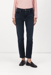 Jeans de mezclilla azul oscuro con un corte recto. Las características incluyen un cierre de botón y cremallera, cinco bolsillos y sutiles detalles de costura.