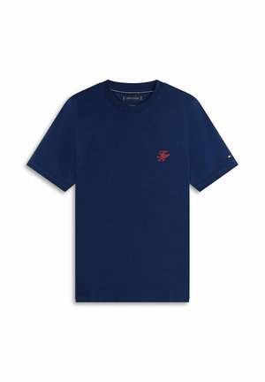Marineblaues T-Shirt mit kurzem Ärmel und Rundhalsausschnitt, mit kleinen roten, gestickten Initialen auf der linken Brust und einem kleinen Flaggenlogo am linken Ärmel.
