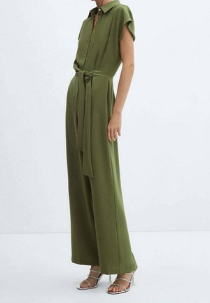 Kombinezon w oliwkowej zieleni z kołnierzykiem, krótkimi rękawami, paskiem w talii i szerokimi nogawkami. Gładka tkanina o strukturalnym kroju.