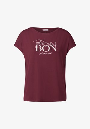 Camiseta de algodón burdeos con un corte relajado, presenta un estampado gráfico con "BON" y "buenas cosas por delante" en blanco. Mangas cortas, escote redondo.