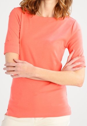 Korallenfarbenes Kurzarmoberteil aus weicher Baumwolle mit rundem Ausschnitt und umgeschlagenen Ärmelabschlüssen, in einem schlanken Schnitt.