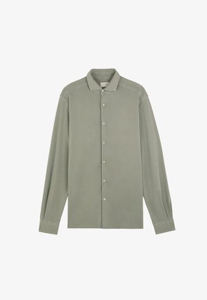 Camisa de manga larga color verde salvia con botones, cuello y pequeño logo bordado de calavera en el pecho izquierdo.