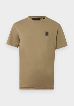 Brown cotton t-shirt with a round neck, short sleeves, and a small black logo patch on the left chest. Smooth texture with a relaxed fit.