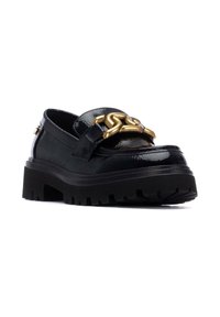 Mocasines de charol negros con suela de plataforma gruesa, que cuentan con un detalle de cadena dorada en la parte superior y un acabado texturizado para añadir dimensión.