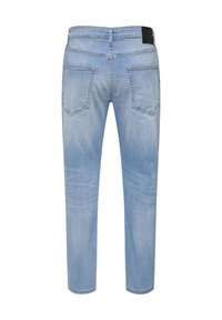 Jean en denim bleu clair vu de dos avec deux poches arrière et une étiquette noire à la taille.