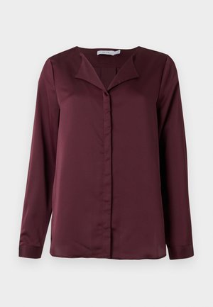 Blusa bordeaux a maniche lunghe con colletto, chiusura frontale a bottoni, texture liscia e design sobrio.