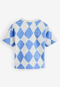 Camiseta de algodón de manga corta con fondo blanco y patrones de diamantes azules y diseños de caras sonrientes en toda su superficie.
