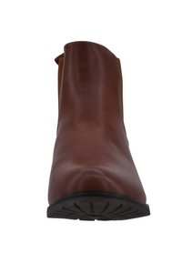 Bota de tobillo de cuero marrón con superficie lisa, punta redondeada, diseño sin cordones y suela de goma negra con un patrón de relieve.
