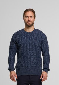 Granatowy sweter z dzianiny o teksturowanym wzorze, okrągłym dekolcie i prążkowanych mankietach. Materiał wydaje się gruby i ciepły.