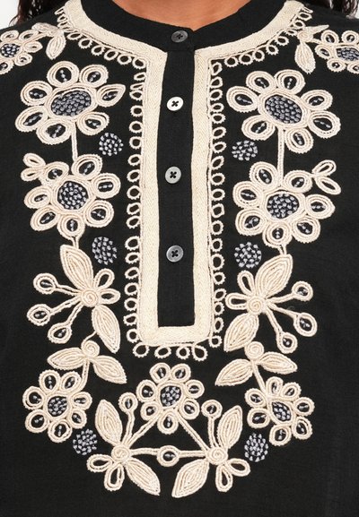 Čierny odev s precízne vypracovanou krémovou a šedou kvetinovou výšivkou, s gombíkovým výstrihom a textúrovanými detailmi.