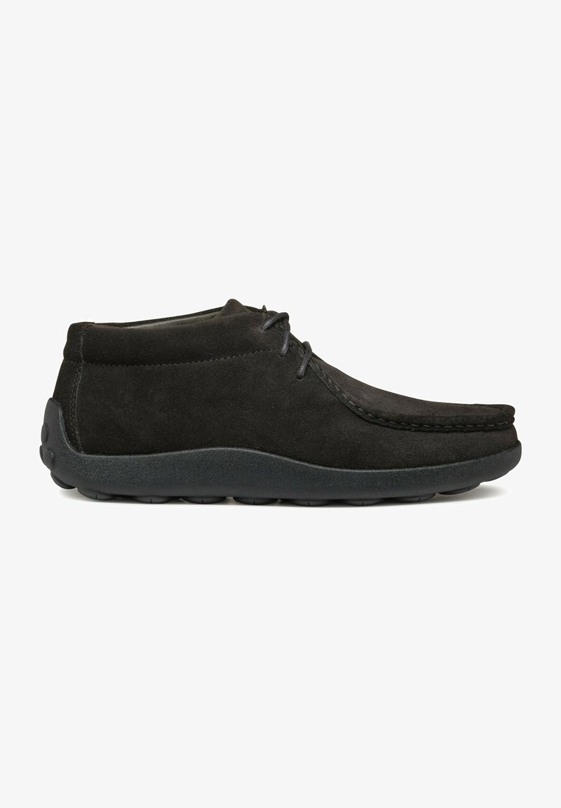 Stivaletti neri in suede con punta rotonda, dettagli di cucitura e suola in gomma nera, progettati per comfort e uso quotidiano.