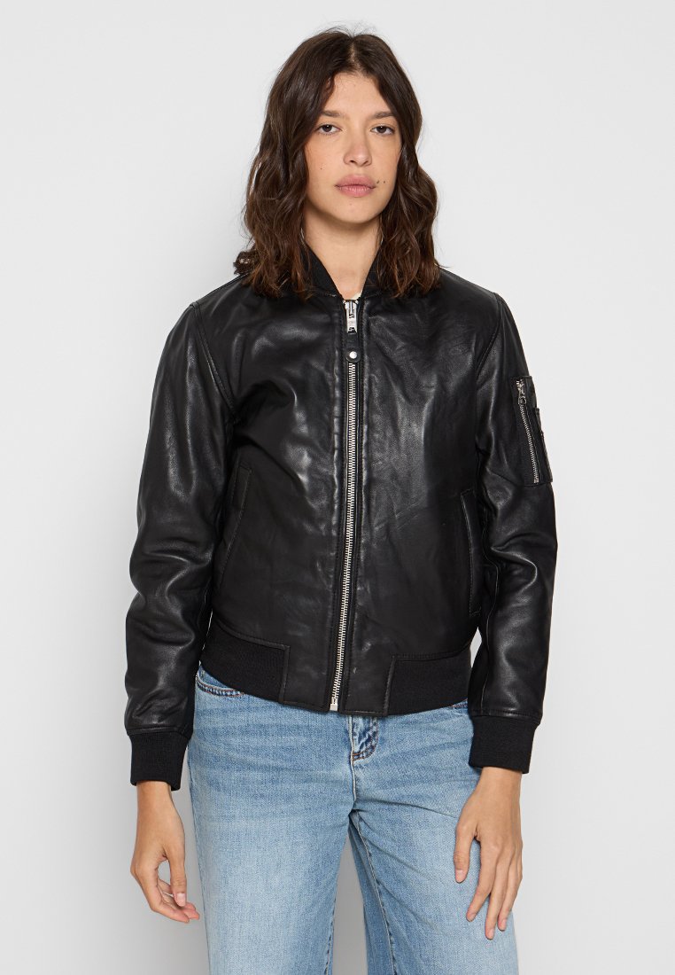 Veste bomber en cuir noir avec fermeture éclair à l'avant, poignets côtelés et poches latérales. Dispose d'une poche zippée sur le bras gauche et d'une texture lisse.
