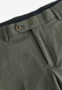 Trousers in olive green, made of textured fabric. Features a button closure, belt loops, and a smooth inner lining.