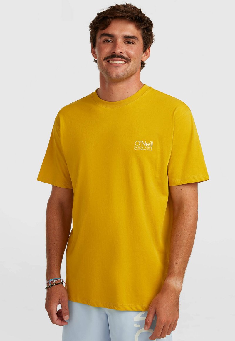 Κίτρινο βαμβακερό T-shirt με στρογγυλή λαιμόκοψη και κοντά μανίκια, με μικρό λευκό λογότυπο στην αριστερή πλευρά του στήθους.