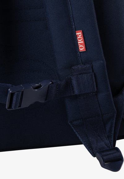 Navy plava torba sa remenom featuring plastičnu kopču, teksturiranu tkaninu i malu crvenu oznaku "POLO". Čvrst dizajn s podesivim karakteristikama.