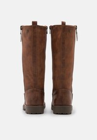 Bottes hautes jusqu'au genou en cuir marron avec une finition texturée, fermetures éclair latérales et semelles renforcées, présentant une silhouette élégante et des coutures minimales.