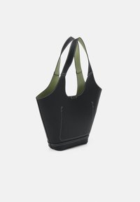 Černá taška přes rameno s bílým prošíváním, olivově zeleným interiérem a dvěma středně dlouhými ušima na bílém pozadí.