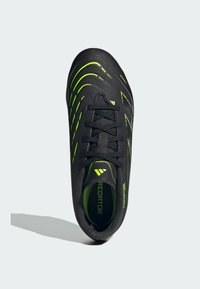 Czarne buty piłkarskie z zielonymi akcentami, teksturowana cholewka, smukły design i tradycyjne sznurowanie. Wewnątrz znajduje się logotyp.