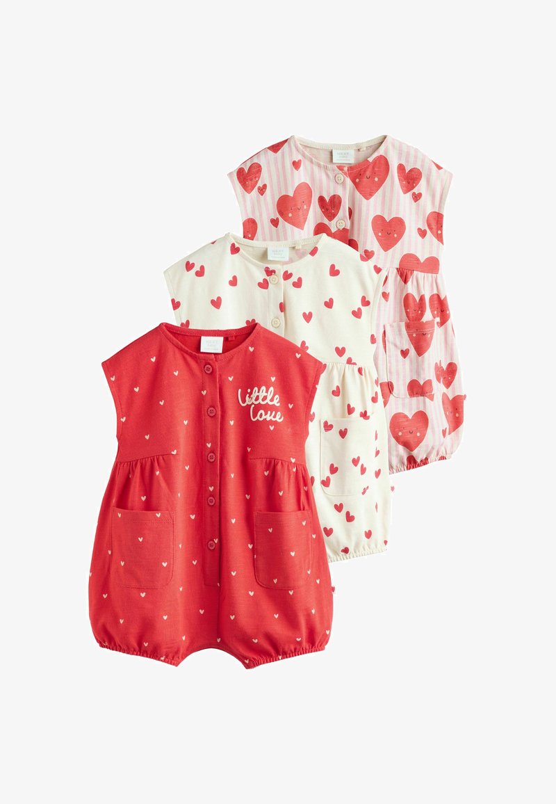 Három csecsemőkezeslábas piros és fehér színben. Az egyik piros szíveket ábrázol, a másik csíkos mintás szívekkel, a harmadik pedig "kis szerelem" feliratot visel.