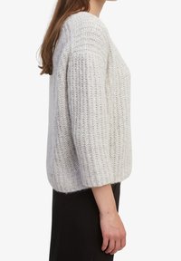 Lichtgrijze gebreide trui met een losse pasvorm, brede mouwen, ribbelstructuur en een middelmatige lengte van de zoom, met een ronde halslijn.