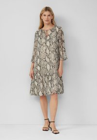 Leichtes Kleid im Schlangendruck-Muster, mit einem Schlüsselaugenhals, Dreiviertelärmel und einem ausgestellten Saum. Farbschema: beige und braun.