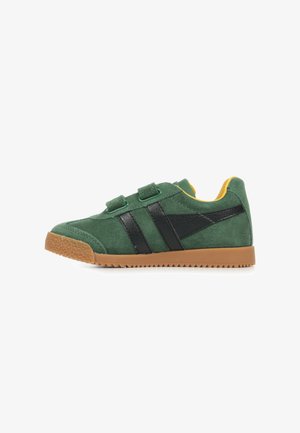 Sneaker verde in suede con due strisce nere, due cinturini in velcro, suola in gomma color beige e rivestimento interno giallo, vista laterale.