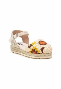 Espadrille beige avec une bride au niveau de la cheville, ornée d'un motif floral coloré brodé sur le bout et d'une semelle en jute recouverte.