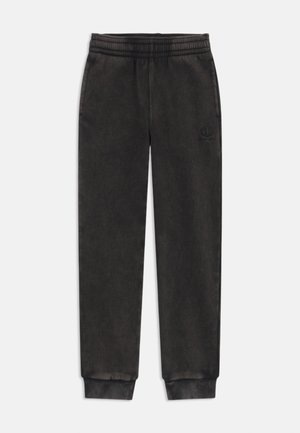 Pantalons de survêtement noirs en tissu doux avec une taille élastique, des jambes fuselées et un petit logo brodé sur la cuisse gauche.