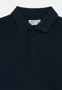 Granatowa koszulka polo z miękkiego materiału z kołnierzykiem, trzema czarnymi guzikami i metką wewnątrz kołnierza.