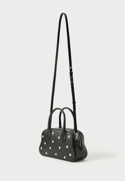 Black leather handbag with silver dot accents, two top handles, and an adjustable shoulder strap. Smooth texture and rounded shape.