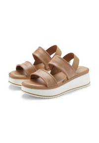 Tan leather sandals with two wide straps, elastic sides, and a white platform sole featuring a textured bottom.
