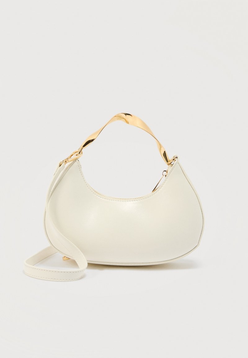 Sac à main crème en forme de croissant avec poignée courte brillante dorée et bandoulière longue assortie sur un fond clair uni.