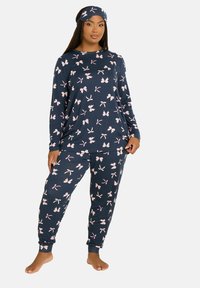 Granatowy zestaw piżamowy z długim rękawem i spodniami dresowymi w różowy wzór w kokardki. W zestawie znajduje się pasująca opaska na głowę. Miękki, elastyczny materiał.