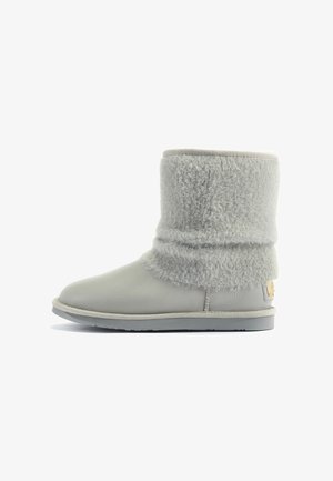 Grijze enkelboot van soepel leer met een fluffy bovenrand van bont en een platte rubberen zool, voorzien van een klein metalen logo accent.