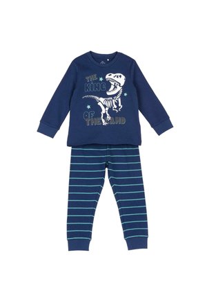 Haut à manches longues bleu marine avec squelette de dinosaure blanc et texte « The King of the Land », associé à un pantalon rayé bleu marine avec des lignes bleu clair.