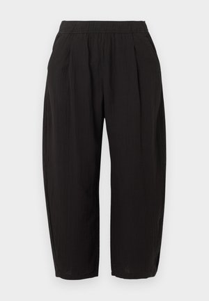 Pantalon noir ample et court avec une ceinture élastique et des poches latérales, présenté sur un fond clair uni.
