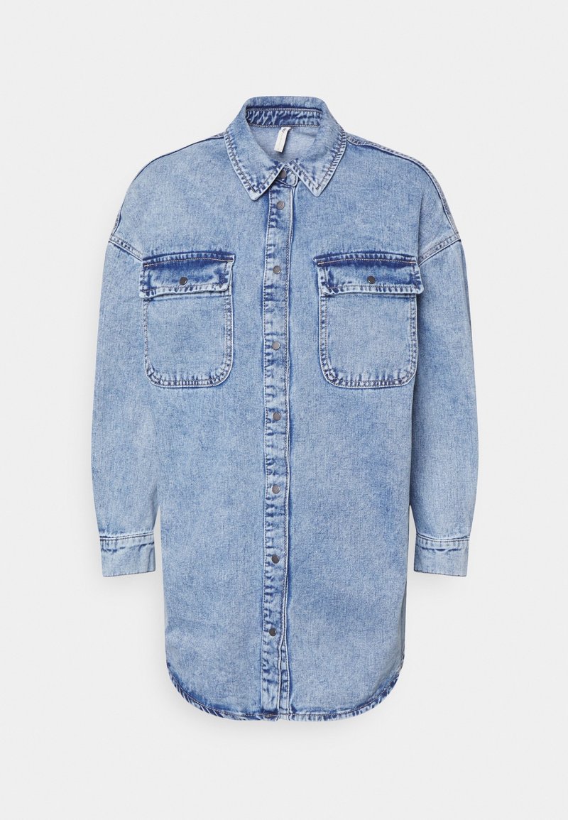 Chemise en denim bleu clair à manches longues, col à revers, deux poches avant et ourlet droit ; elle présente une fermeture à boutons et des coutures visibles.