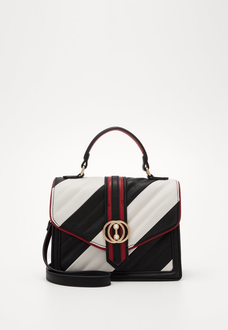 Sac à main rayé diagonal noir et blanc avec finition rouge, fermoir circulaire doré orné de perles, poignée supérieure et bandoulière amovible.